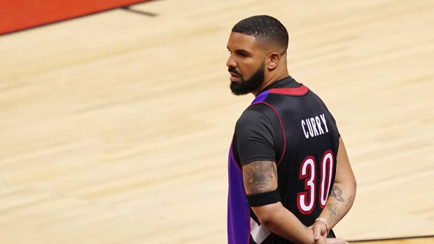 Drake standing courtside.